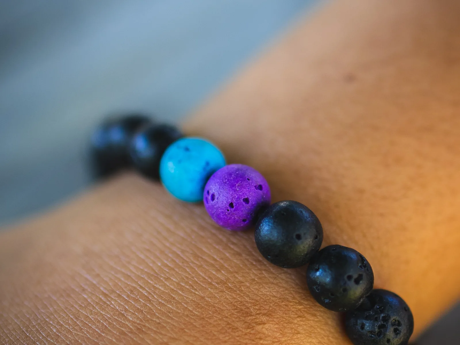 Close-up of a handmade Volcanic Vibes bracelet with purple and turquoise accent beads